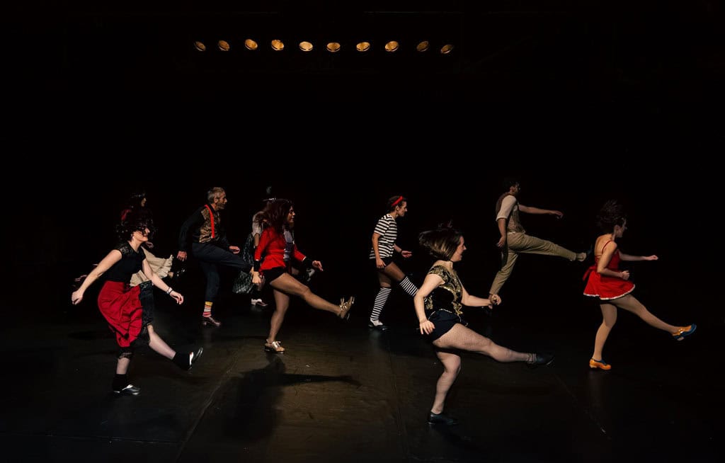 Niños bailando claqué en estudio de danza, en movimiento y sincronización.