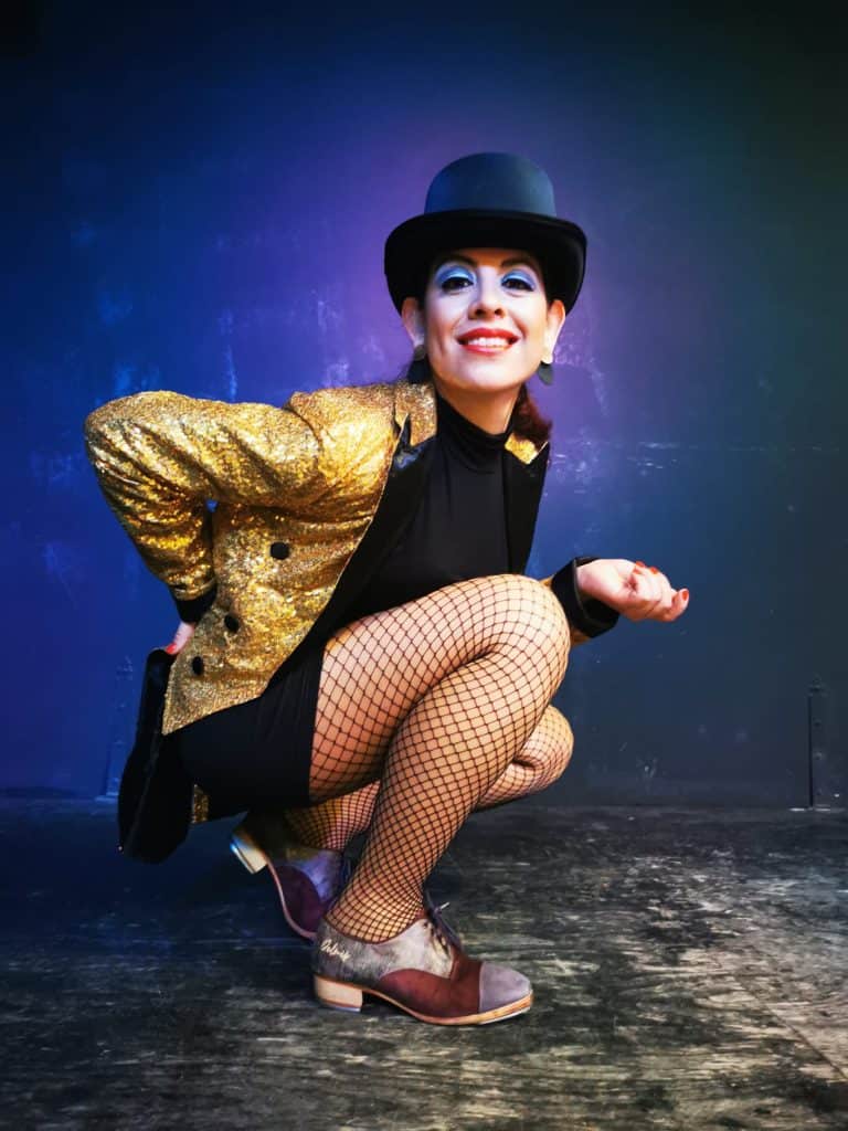 Espectáculo de danza artística con vestuario brillante y expresión enérgica. Bailarina en pose de danza artística con vestuario llamativo y expresión enérgica.