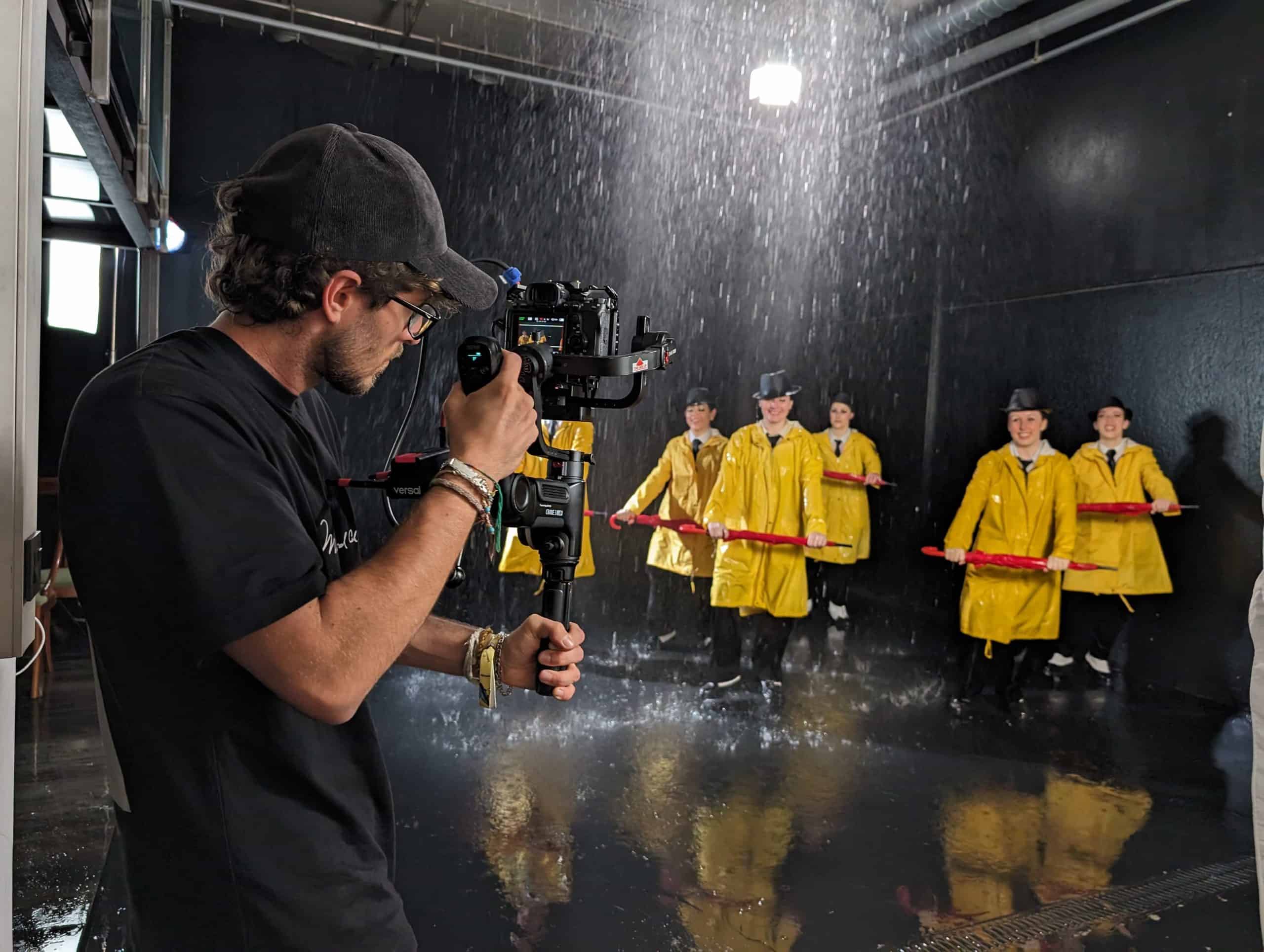 Captura de un video musical en estudio de danza con bailarines en vestimenta amarilla.