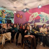 Grupo de personas disfrutando en un estudio de danza con arte mural y ambiente vibrante. Bailarinas en un ambiente acogedor y moderno, ideal para clases y eventos de danza.